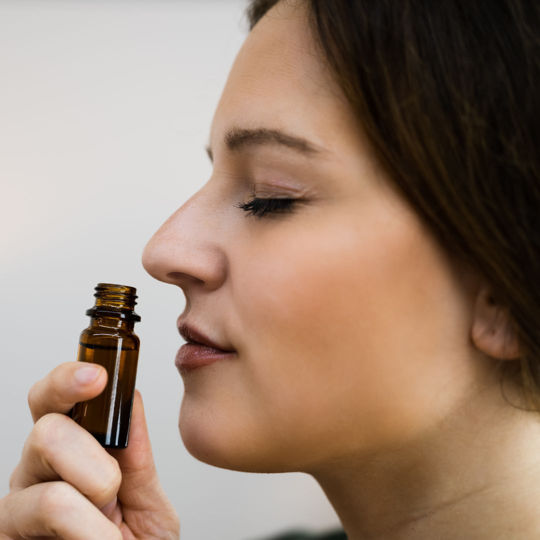 woman smelling essential oils