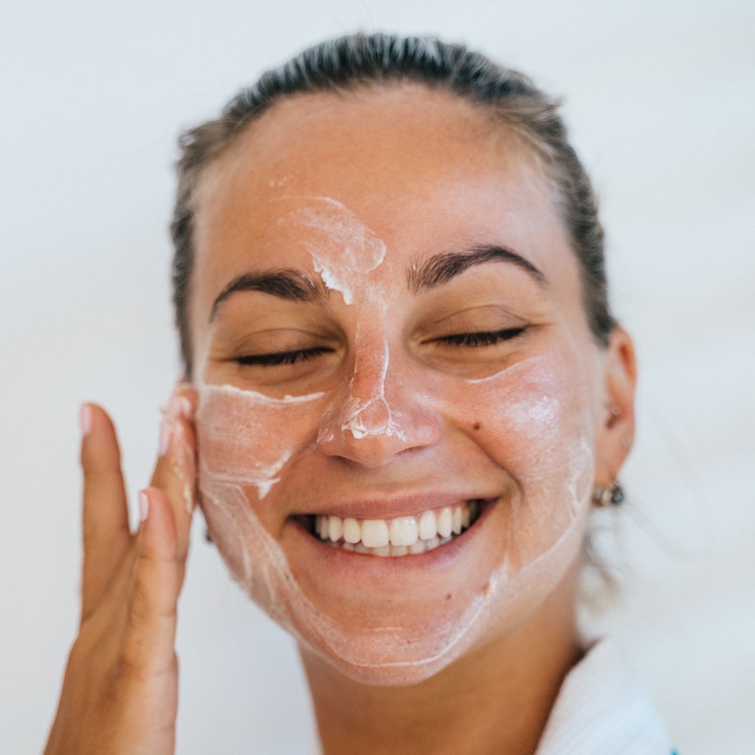 Woman putting sunscreen on her face